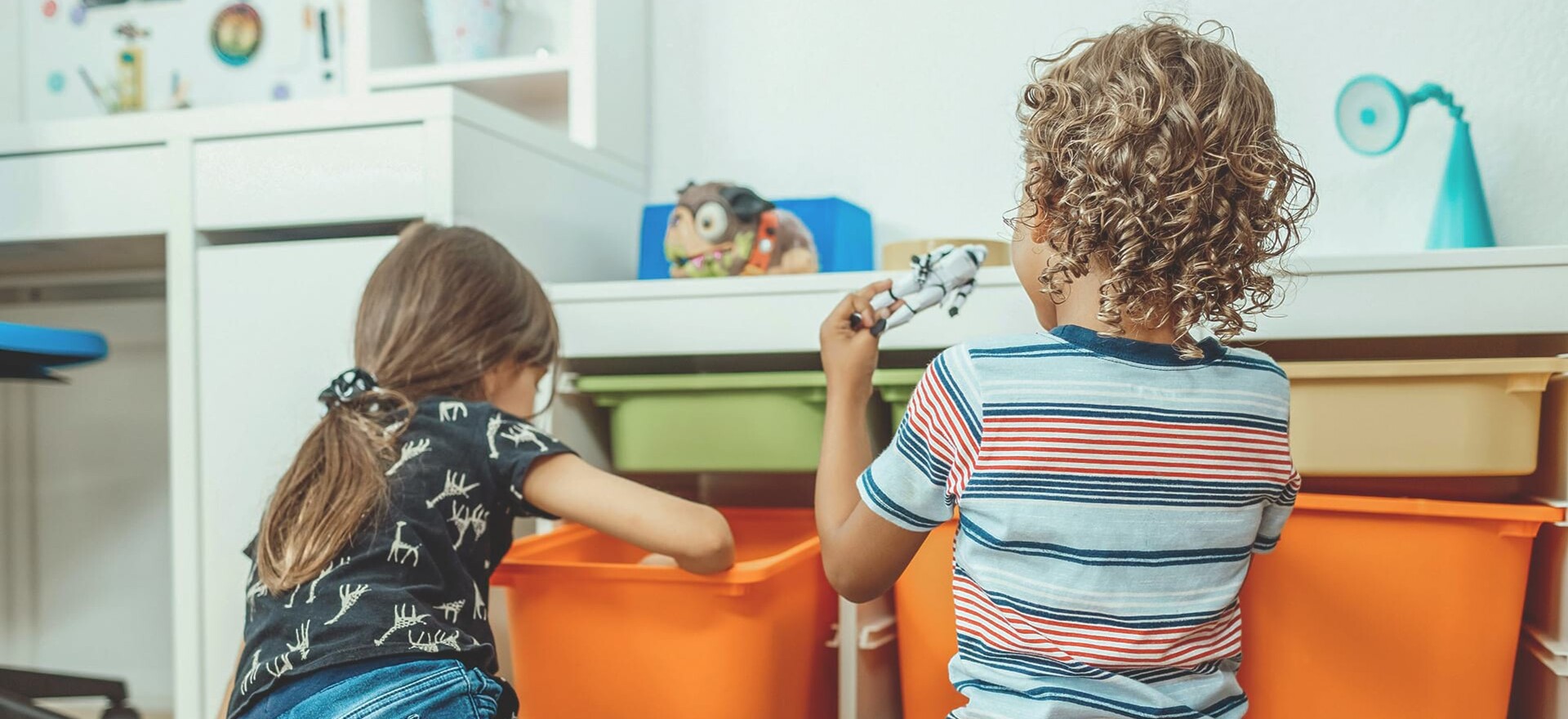 Zwei Kinder sitzen im Wartezimmer und spielen mit Spielzeug.